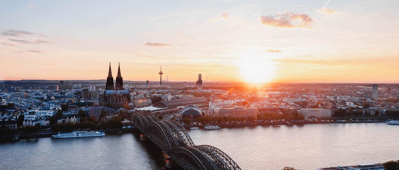 Sonnenuntergang fotografiert von der linken Rheinseite. Man sieht den Kölner Dom und die Hohenzollernbrücke.